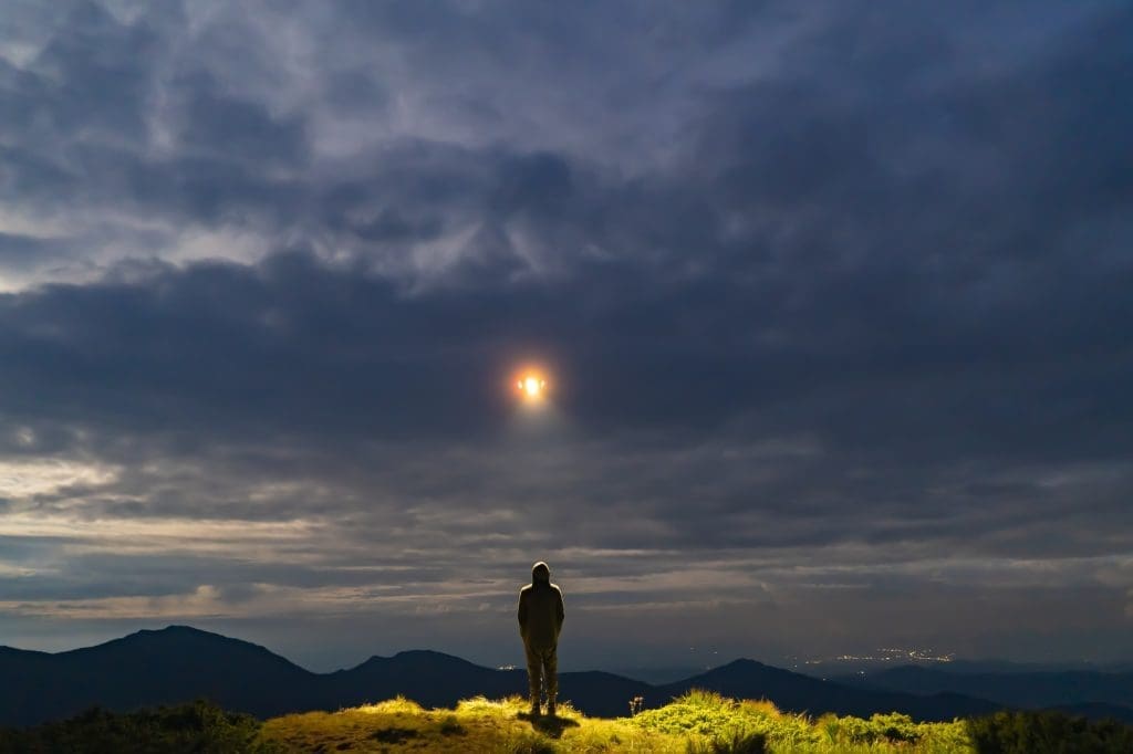 Roswell Incident Investigation The UFO shines on a male standing on the mountain